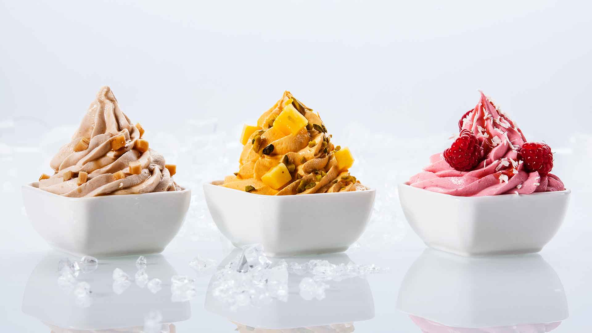 Three bowls of different flavors of ice cream on a light background