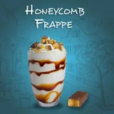 Honeycomb frappe with whipped cream and caramel sauce on a blue background